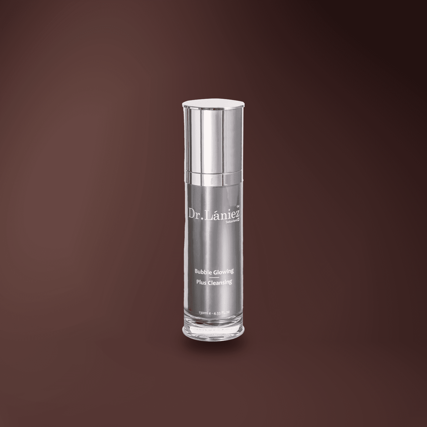 Silver pump bottle of Bubble Glowing Plus Cleansing, 130 ml, lit on a warm plum studio backdrop.